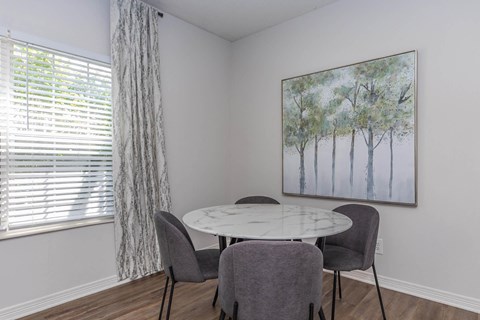 a dining room with a table and chairs and a window