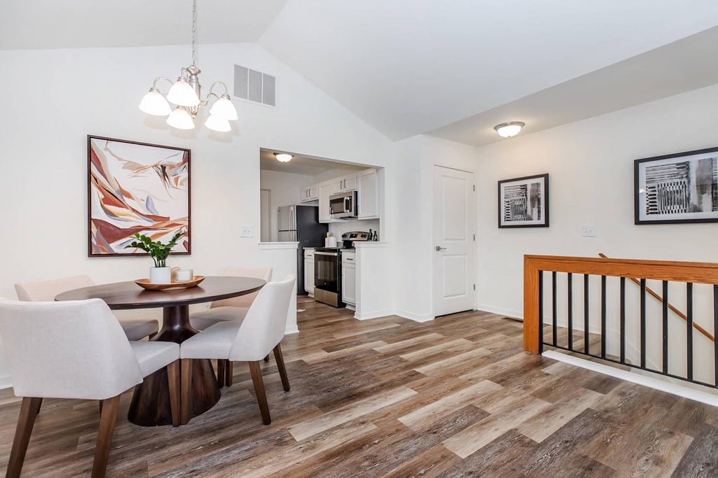 a dining room with a table and chairs next to a kitchen