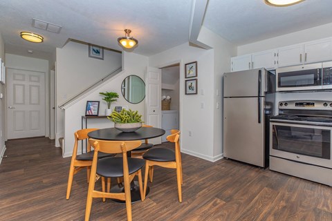 a kitchen with stainless steel appliances and a table and chairs