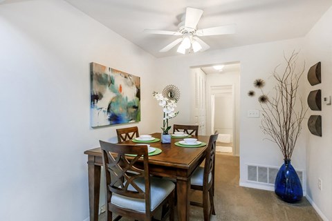 a dining room with a table and chairs and a ceiling fan