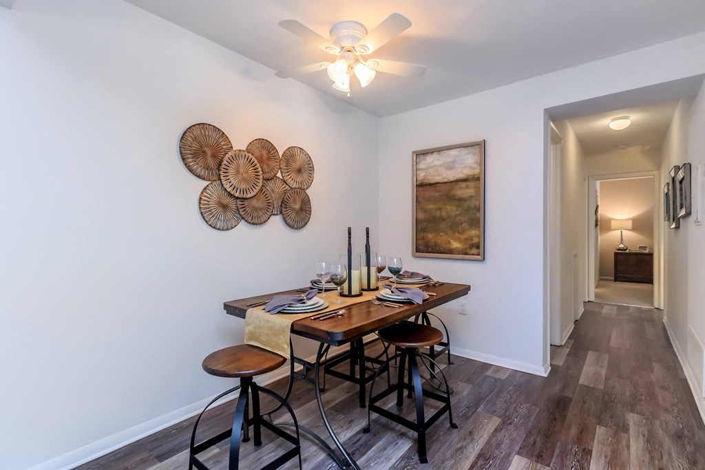a dining room with a table and chairs and a ceiling fan
