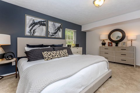 a bedroom with blue walls and a white bed
