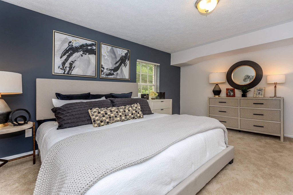 a bedroom with blue walls and a white bed