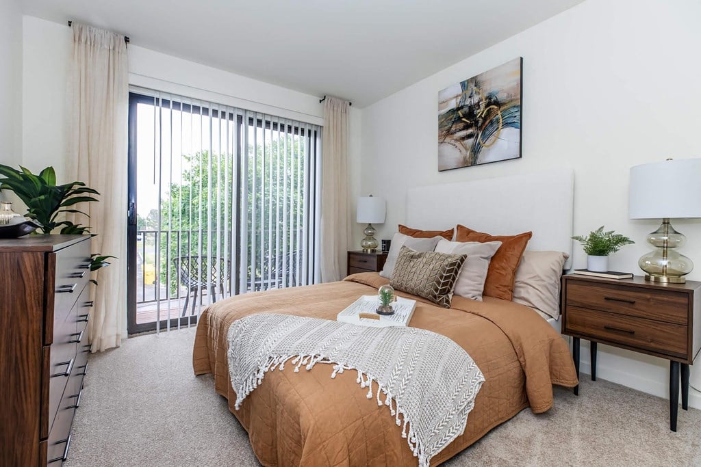 a bedroom with a bed and a sliding glass door