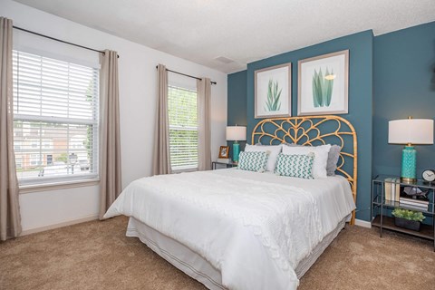A bedroom with a white bed and a gold headboard.