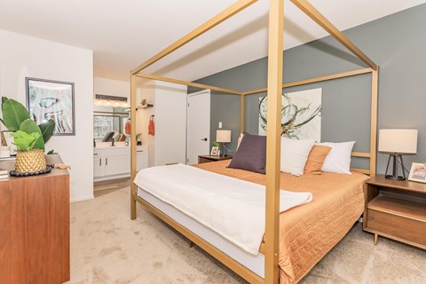 a bedroom with a bed in a gold canopy
