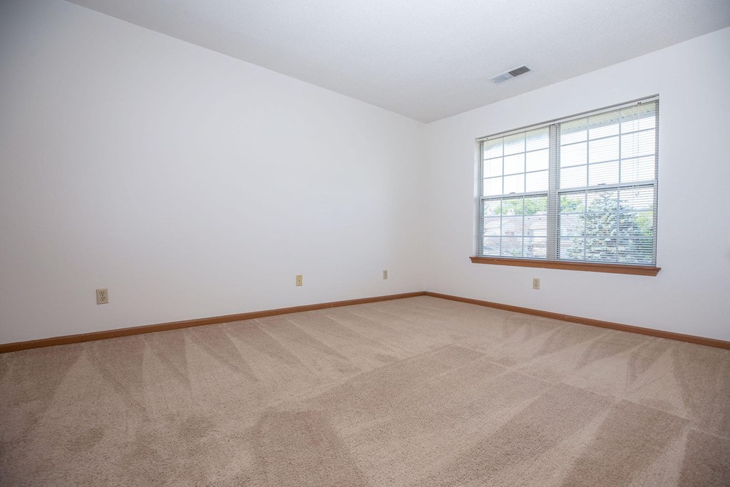 the living room of a home with carpet and a window