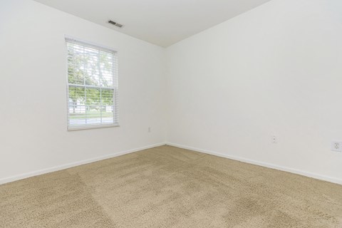an empty room with carpet and a window