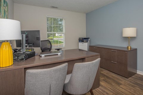 a office with a desk and chairs and a computer