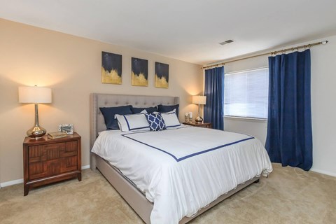 a bedroom with a bed and a window with blue curtains