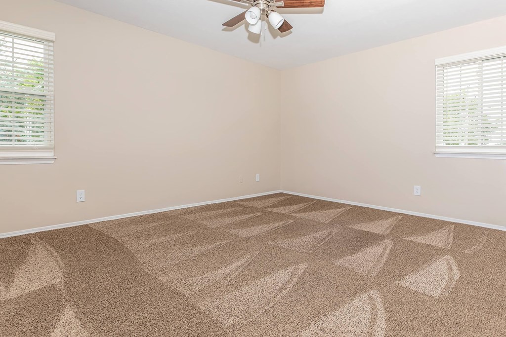 a room with carpet and a ceiling fan