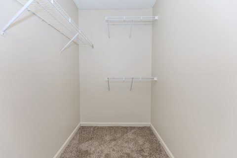 A small, empty room with a carpeted floor and white walls.
