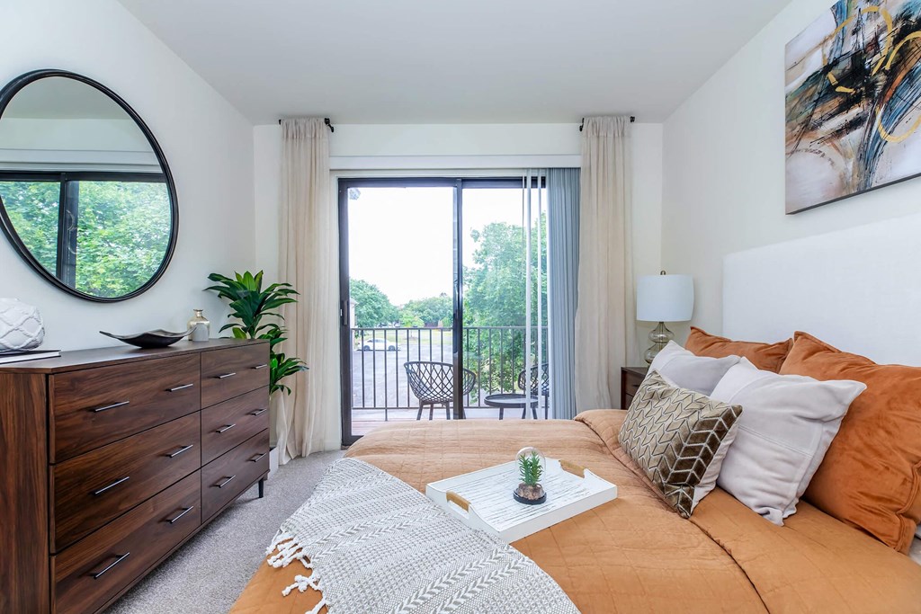 a bedroom with a couch and a door to a balcony