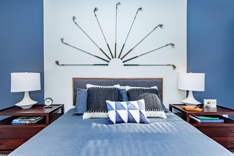 a bedroom with blue walls and a bed with pillows