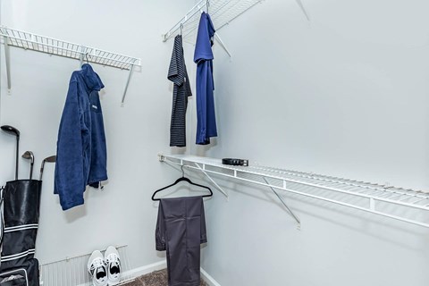a closet with robes and clothes hanging on the wall