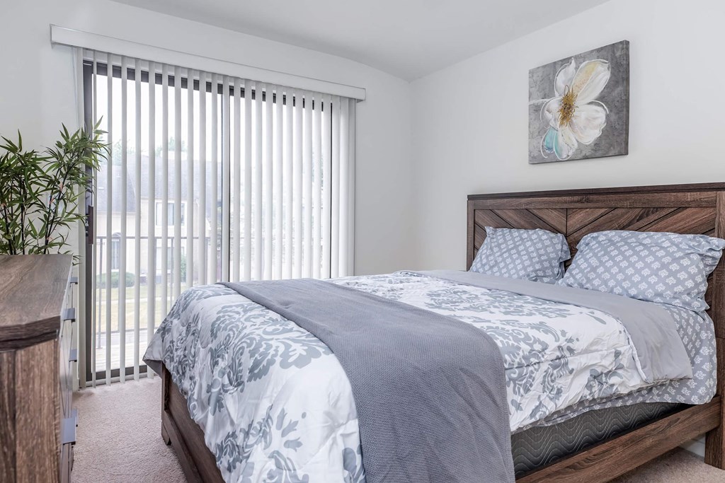 a bedroom with a bed and a large window