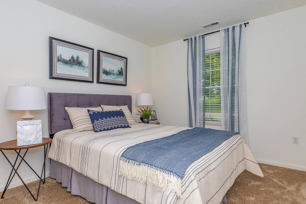 a bedroom with a bed and a large window