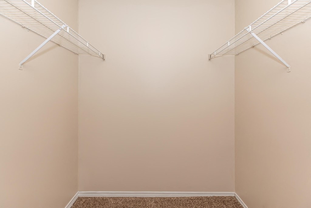 a walk in closet with two white rails on the wall