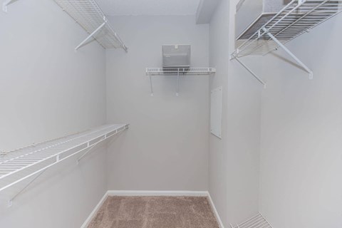 a walk in closet with shelves and a dryer