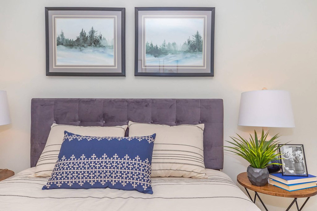 a bedroom with a bed and two pictures on the wall