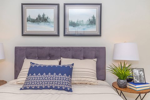 a bedroom with a bed and two pictures on the wall