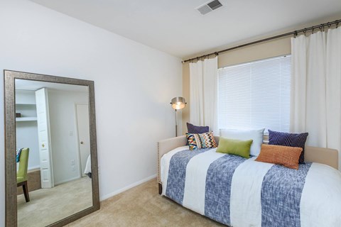 a bedroom with a bed and a mirror