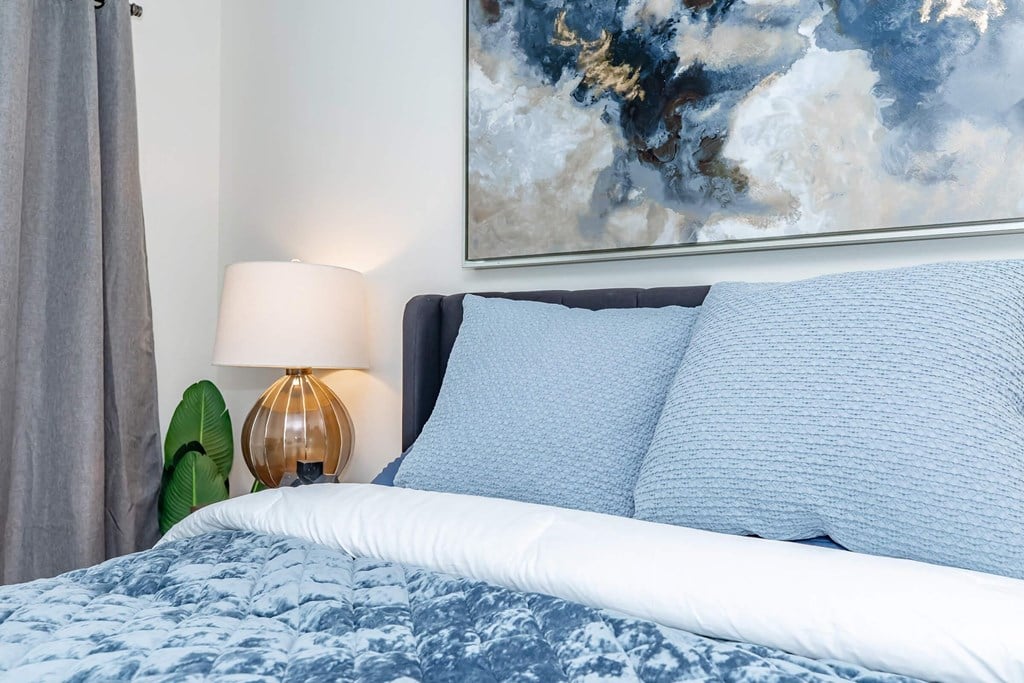 a bedroom with a bed and a painting on the wall