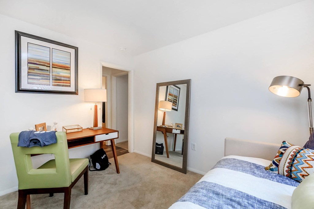 a bedroom with a bed and a desk with a mirror