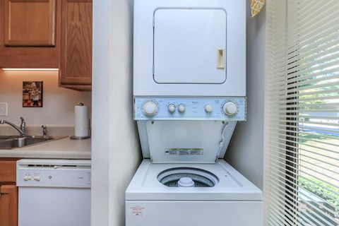 a washer and dryer in a kitchen with a window and a sink