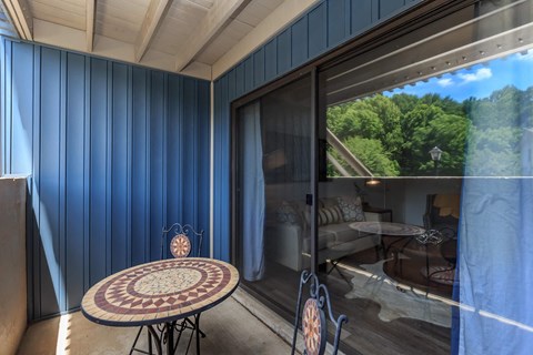 a living room with blue walls and a patio with a table and chairs