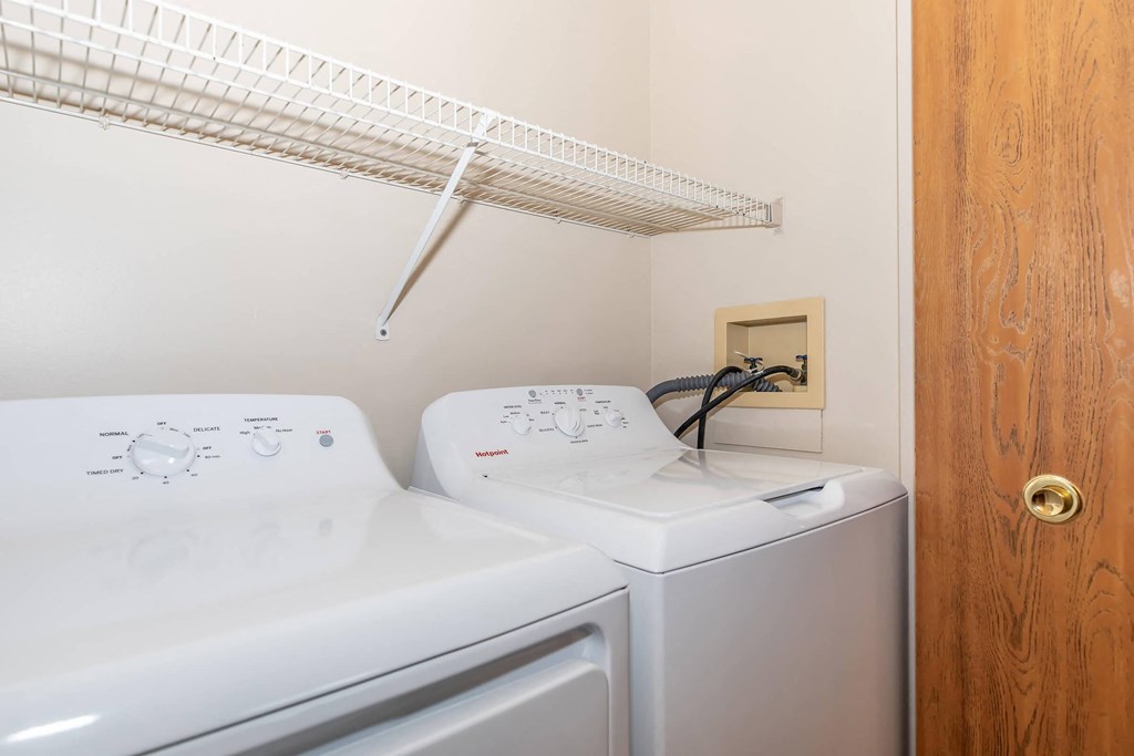 a laundry room with two washes and a dryer   and a shelf