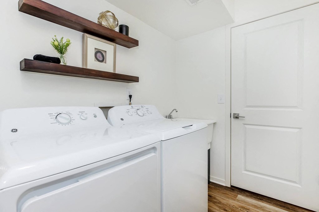 a white washer and dryer in a laundry room with a white door