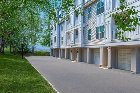 a long asphalt driveway in front of an apartment building
