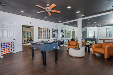 a game room with a pool table and a ceiling fan