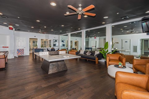 a large living room with leather furniture and a ceiling fan