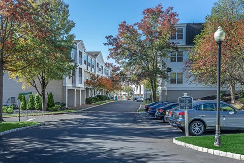 a street with cars parked in front of apartment buildings