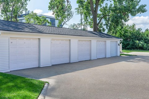 a white garage with white doors and a black roof