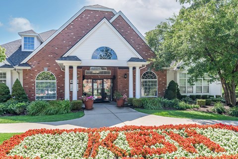 the front facade of a house with a flower garden in front of it