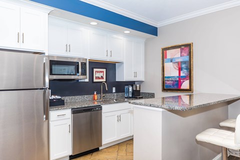 A kitchen with white cabinets and a blue stripe on the wall.
