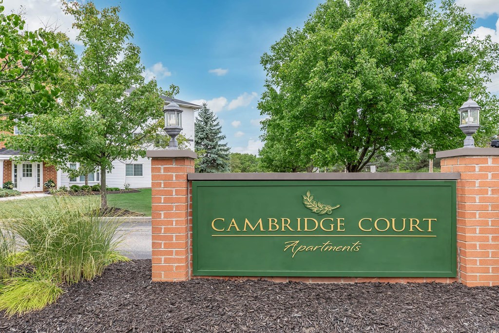 a sign in front of trees and a building