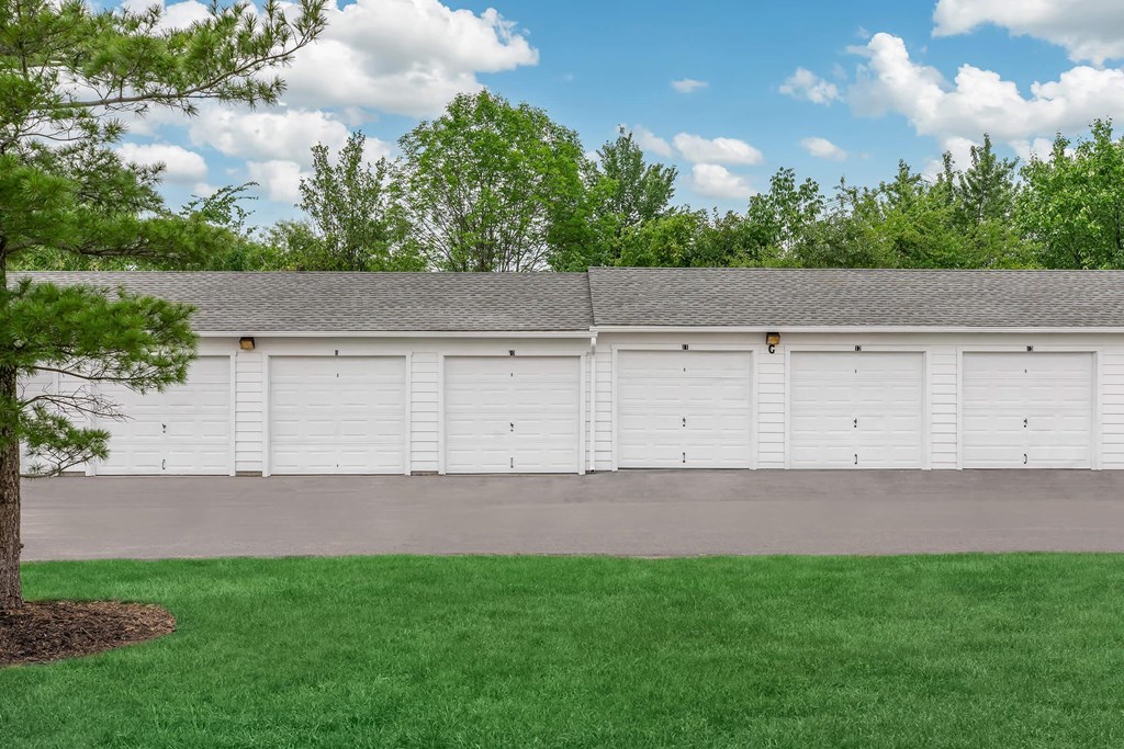a large white garage with white doors and green grass