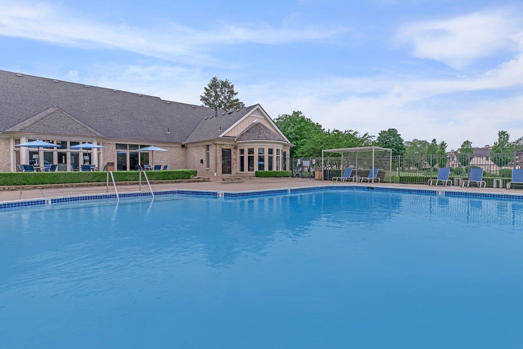 a large pool with a house in the background