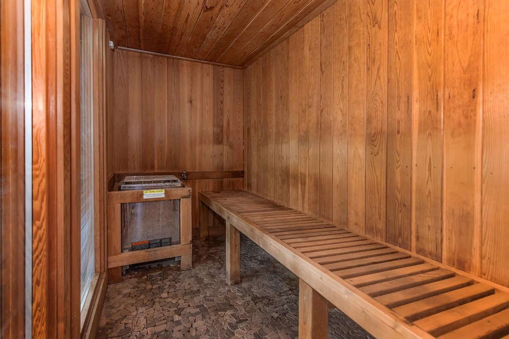 a wooden sauna with wooden benches and a wood stove