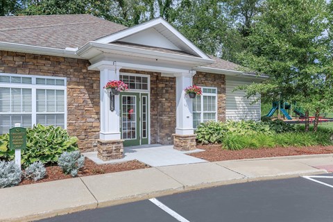 a small brick house with a front porch and a driveway