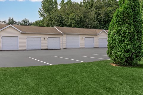 A large building with a grey roof and four garage doors.