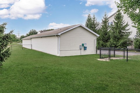 a small white shed with a fence in a yard