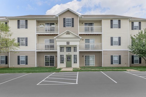 A large apartment complex with a green door and a balcony.