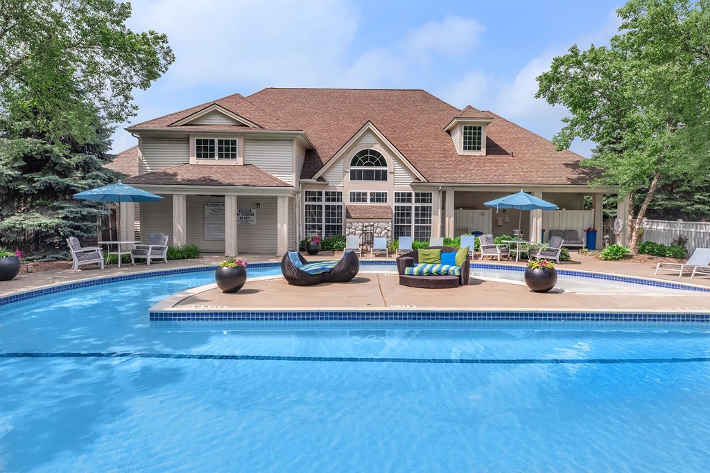 a swimming pool in front of a house with a pool