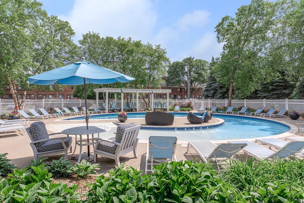 a swimming pool with patio furniture and an umbrella