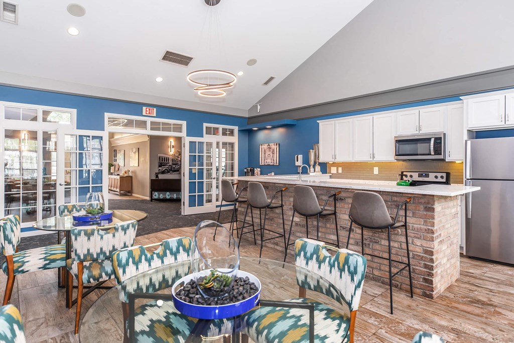 a living room with a kitchen and a table with chairs
